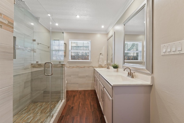 bathroom featuring double vanity, a textured ceiling, a sink, and wood finished floors