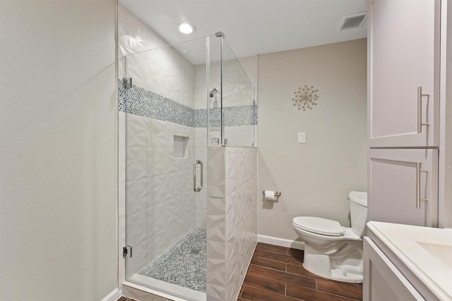 bathroom with visible vents, toilet, wood tiled floor, a shower stall, and baseboards