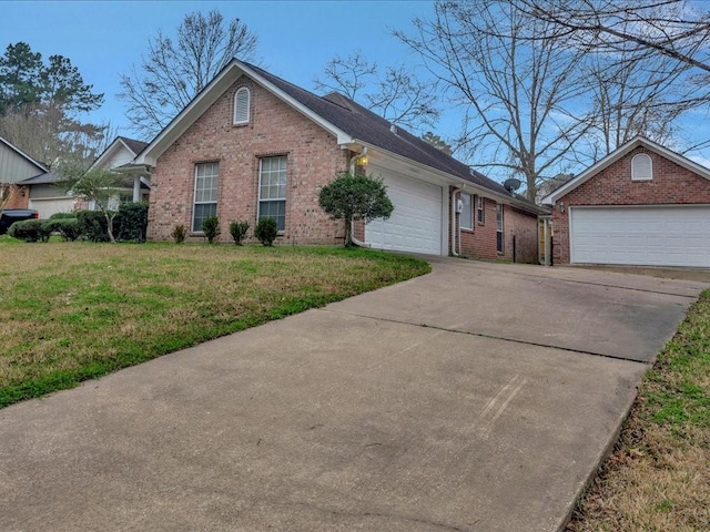 view of front facade with driveway, an attached garage, a front yard, and brick siding