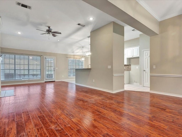 unfurnished living room with a ceiling fan, visible vents, light wood-style floors, and baseboards