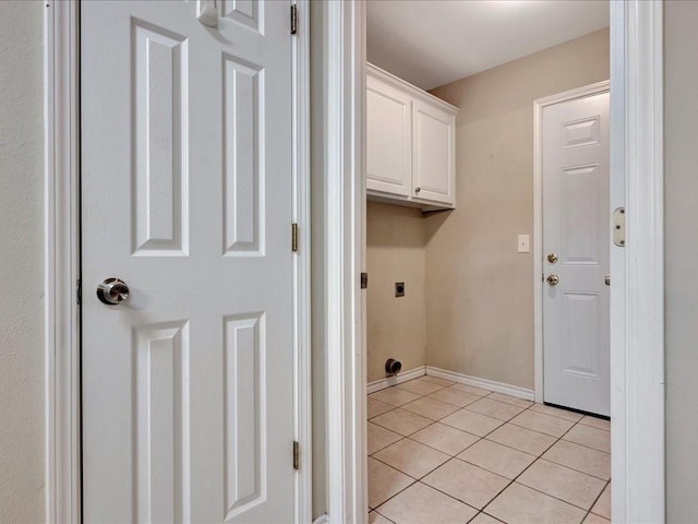 washroom featuring cabinet space, baseboards, electric dryer hookup, and light tile patterned flooring