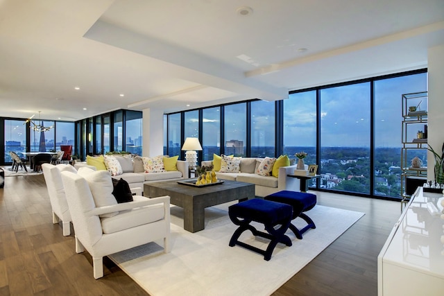 living area with a chandelier, plenty of natural light, wood finished floors, and floor to ceiling windows