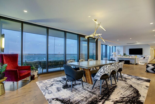 dining space with recessed lighting, a chandelier, wood finished floors, and floor to ceiling windows