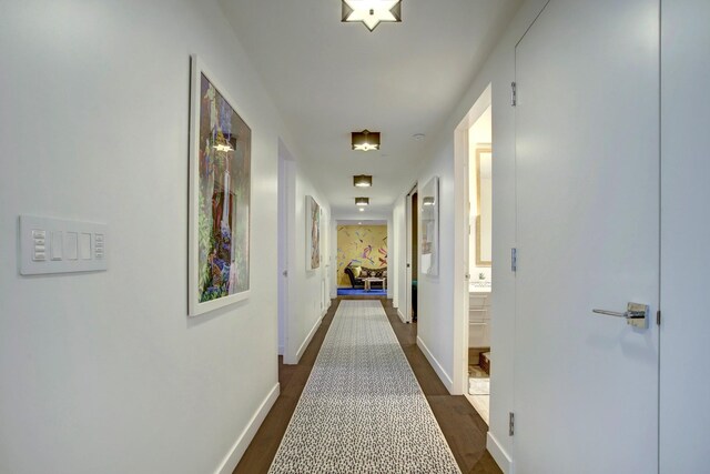 hallway featuring baseboards and dark wood-style flooring