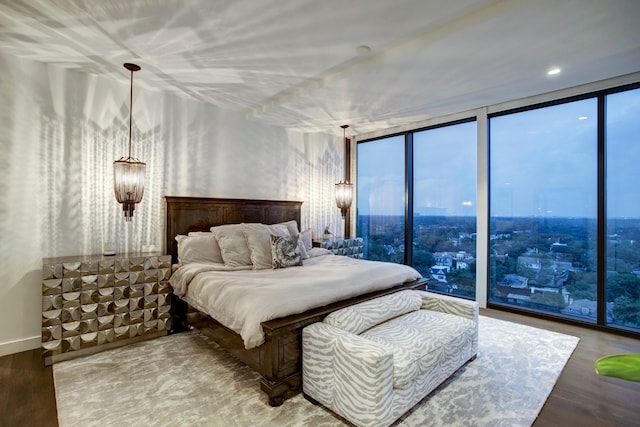 bedroom with expansive windows, multiple windows, and wood finished floors