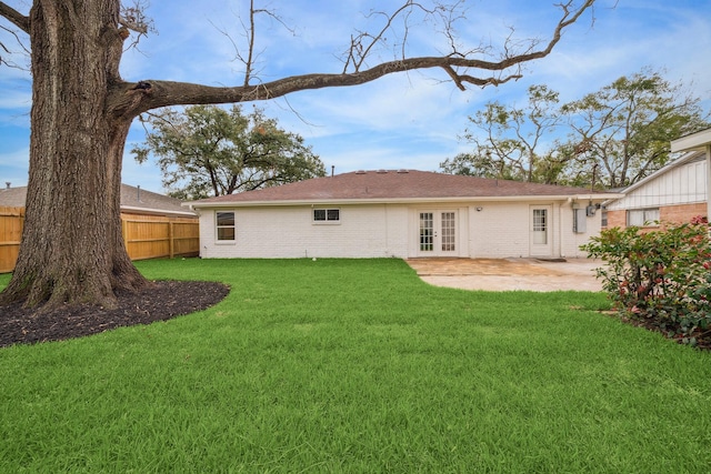 back of house featuring french doors, brick siding, a lawn, a patio area, and fence