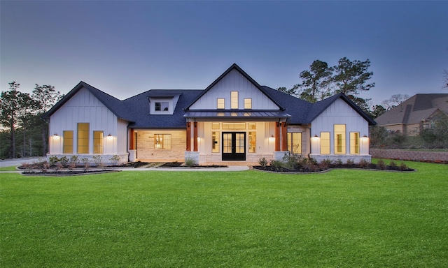 modern farmhouse featuring a standing seam roof, french doors, board and batten siding, and a front lawn