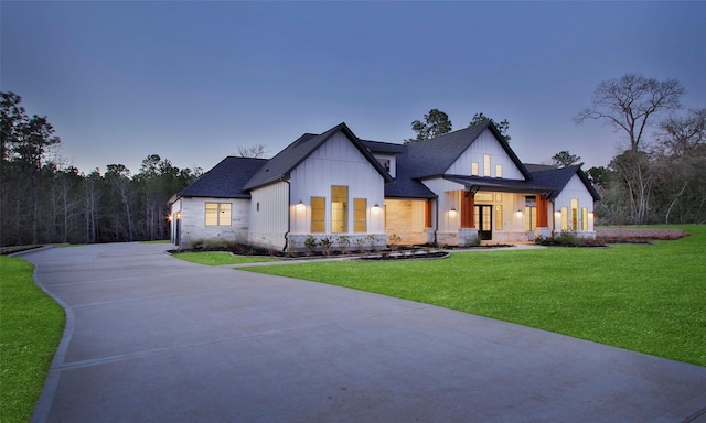 modern inspired farmhouse with a porch, driveway, roof with shingles, board and batten siding, and a front yard