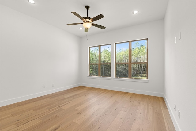 spare room featuring light wood-style floors, baseboards, a ceiling fan, and recessed lighting