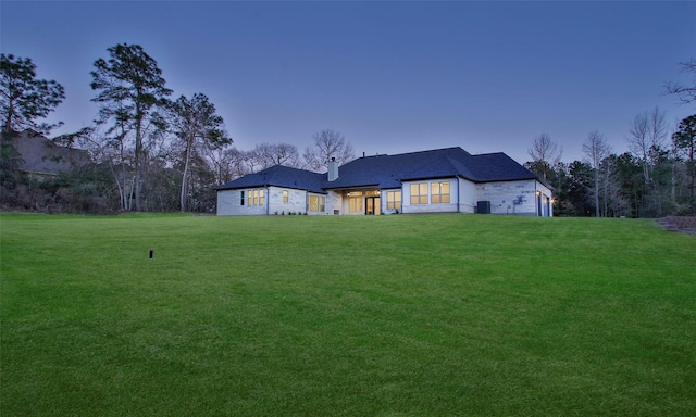 rear view of house featuring a lawn