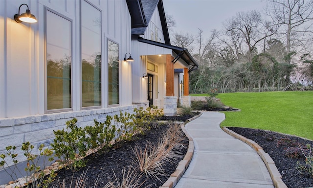 view of home's exterior featuring a yard, a shingled roof, and board and batten siding