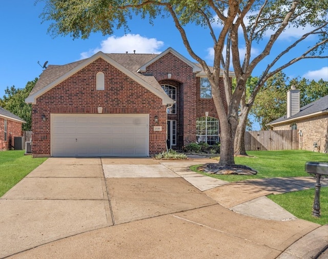 traditional-style house with concrete driveway, an attached garage, fence, a front lawn, and brick siding