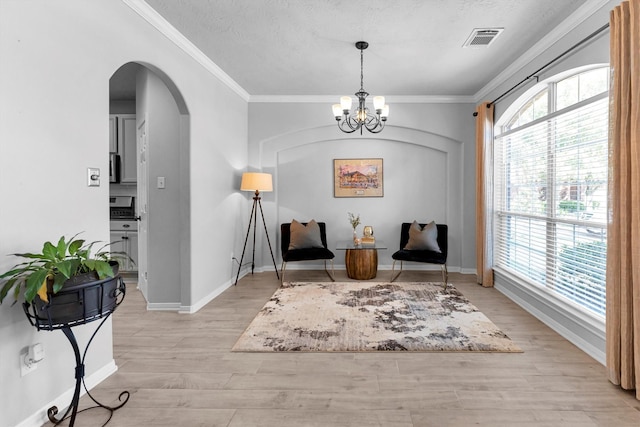 sitting room featuring light wood-style floors, visible vents, and crown molding