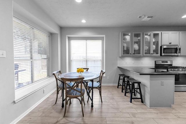 dining room with light wood-style floors, recessed lighting, visible vents, and baseboards