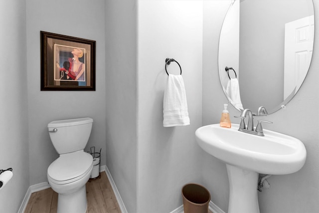 bathroom featuring baseboards, toilet, and wood finished floors