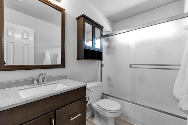 bathroom featuring enclosed tub / shower combo, vanity, and toilet