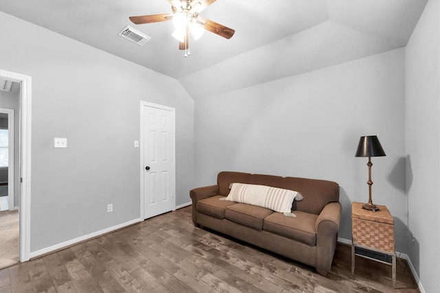 living room with baseboards, visible vents, a ceiling fan, wood finished floors, and vaulted ceiling