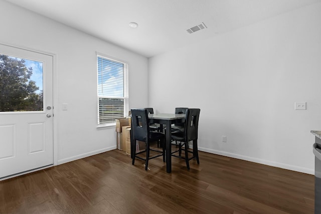 dining room featuring dark wood-style floors, visible vents, and baseboards