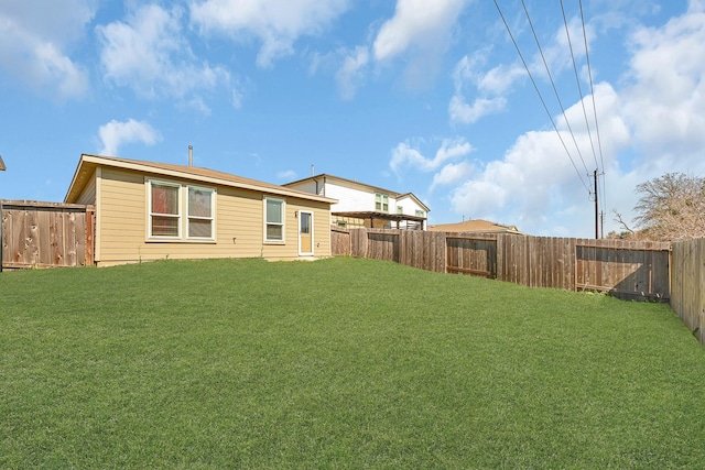 back of house featuring a fenced backyard and a yard