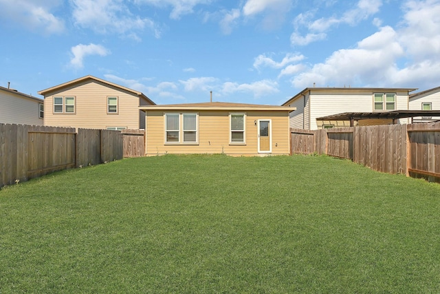 rear view of property with a yard and a fenced backyard