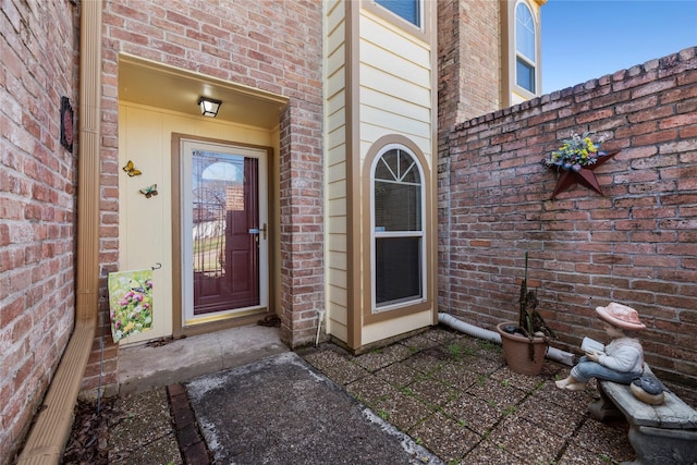 view of exterior entry featuring brick siding