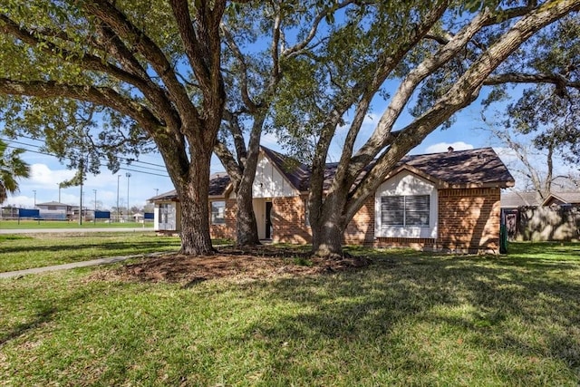 view of front of home featuring a front lawn and brick siding