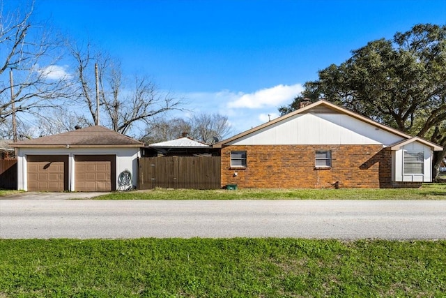 view of home's exterior featuring a yard, fence, and brick siding