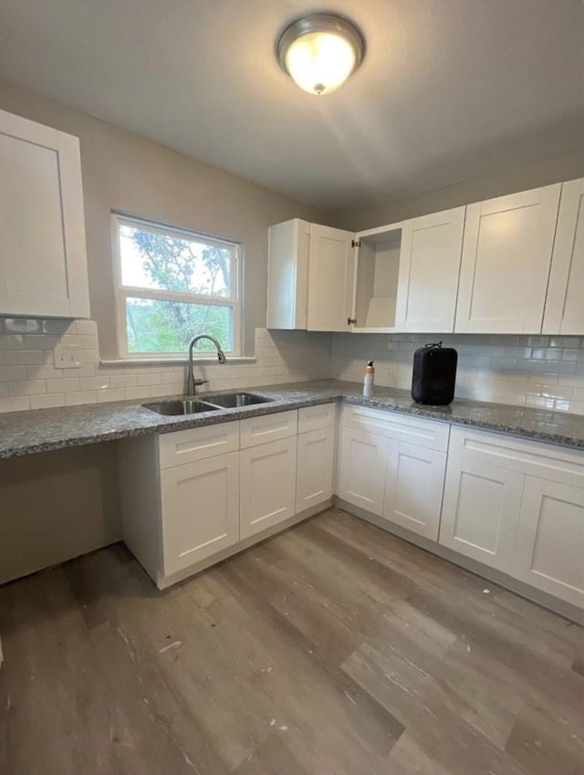 kitchen featuring white cabinets, tasteful backsplash, open shelves, and a sink