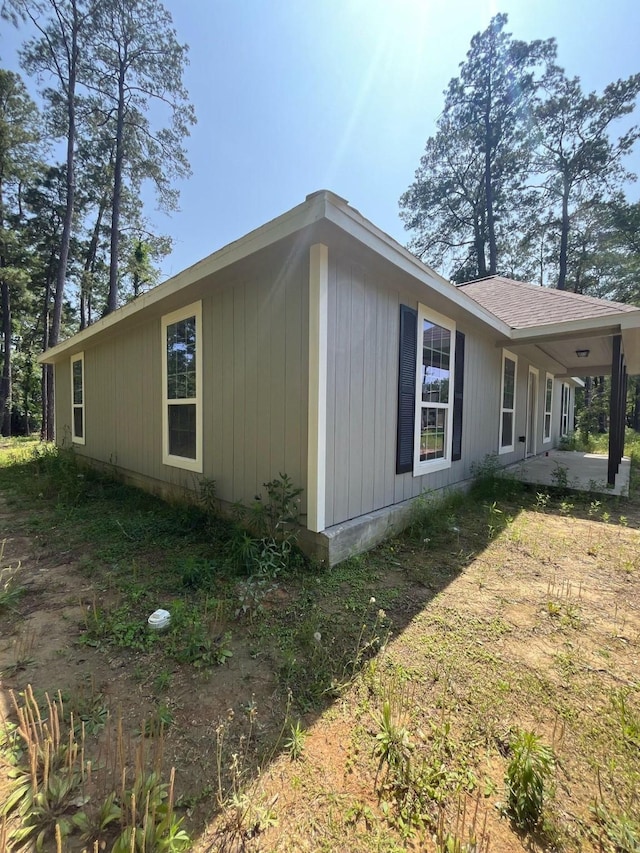 view of side of property featuring a shingled roof