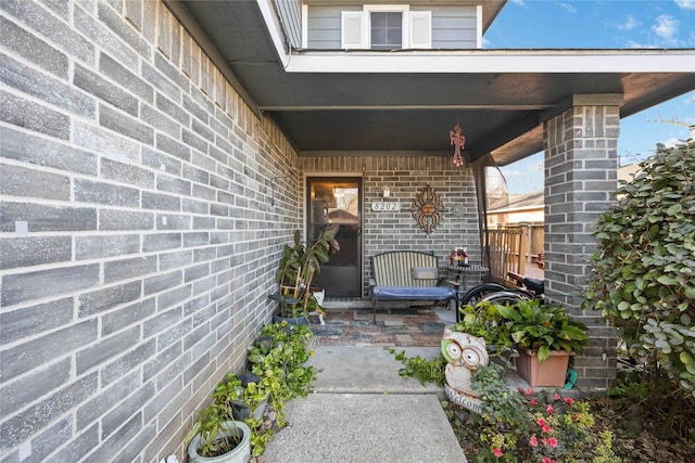 view of exterior entry featuring brick siding