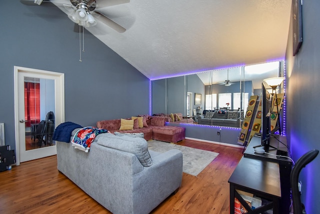 living room with ceiling fan, vaulted ceiling, a textured ceiling, and wood finished floors