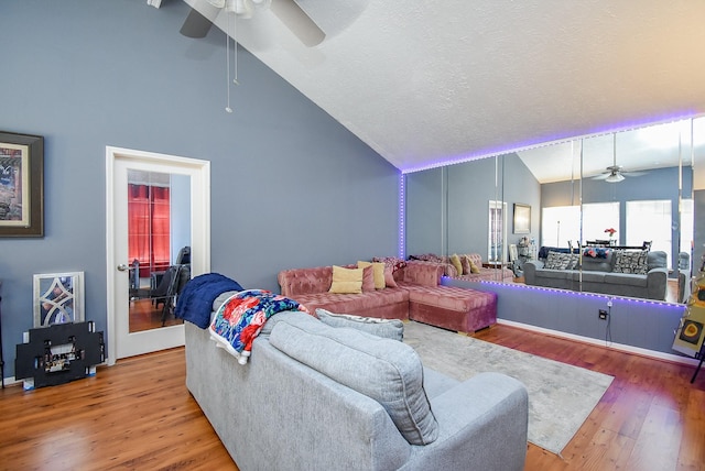 living room with a ceiling fan, high vaulted ceiling, a textured ceiling, and wood finished floors