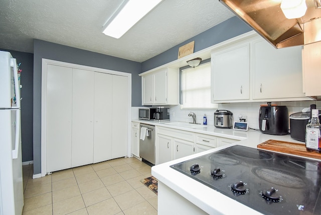 kitchen featuring dishwasher, light countertops, light tile patterned floors, and white cabinetry