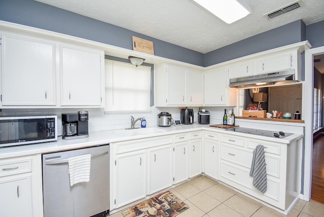 kitchen featuring under cabinet range hood, visible vents, white cabinets, light countertops, and appliances with stainless steel finishes