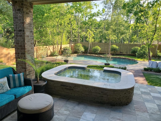 view of swimming pool with a fenced backyard, a patio, a fenced in pool, and an in ground hot tub