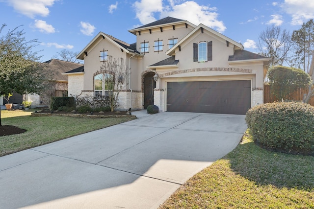 view of front of house with driveway, a garage, fence, a front lawn, and stucco siding