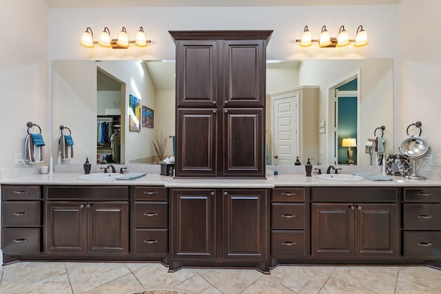 full bath featuring double vanity, a sink, and tile patterned floors