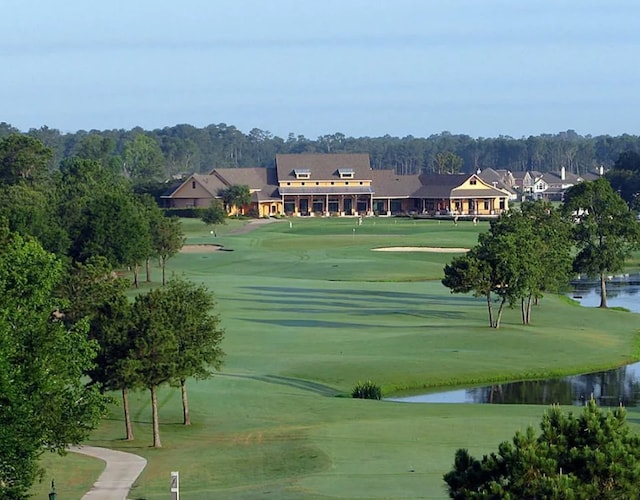 view of community featuring a yard, golf course view, and a water view