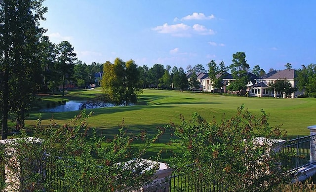 view of home's community featuring a water view and a lawn