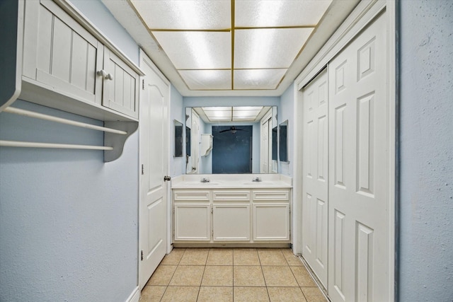 kitchen featuring light tile patterned floors, light countertops, a sink, and white cabinetry