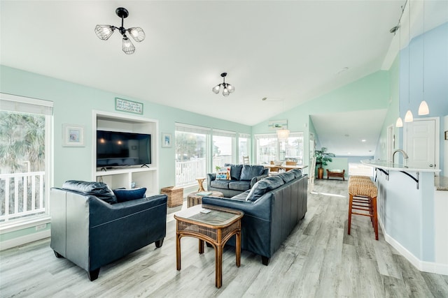 living area with lofted ceiling, light wood-type flooring, and baseboards