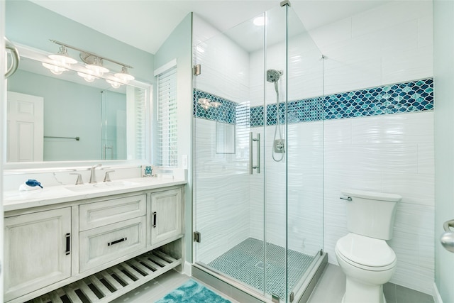 bathroom with toilet, tile patterned flooring, a shower stall, and vanity