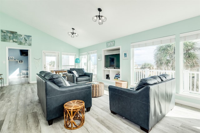 living room featuring light wood-style flooring, a chandelier, vaulted ceiling, and baseboards