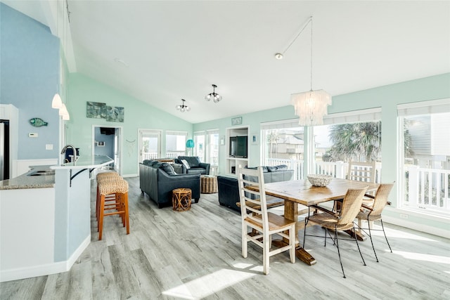 dining room featuring a notable chandelier, high vaulted ceiling, and light wood-style floors