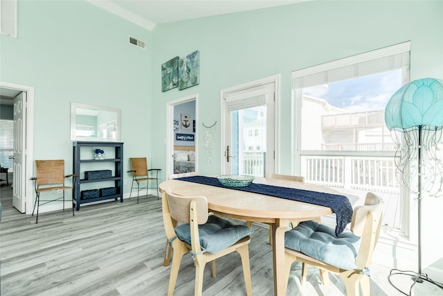 dining room featuring high vaulted ceiling, visible vents, and light wood finished floors