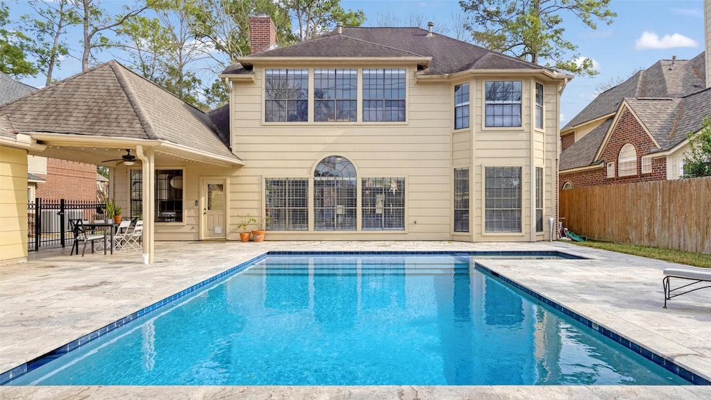 13311 April Mist Ct, Cypress, TX 77429 - back of property featuring a patio, fence, a ceiling fan, a fenced in pool, and a chimney