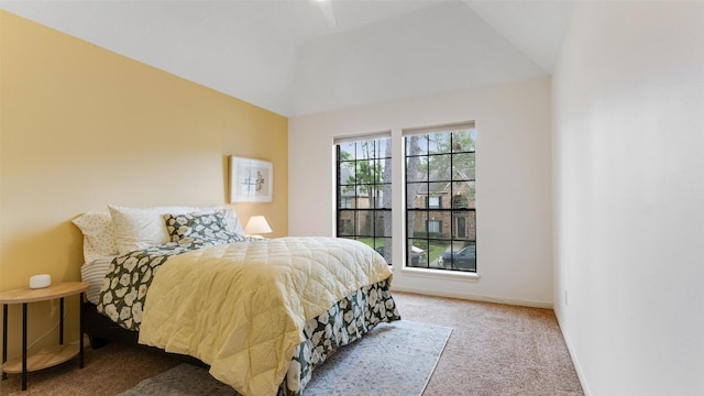 carpeted bedroom with lofted ceiling and baseboards