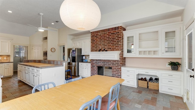 kitchen with stainless steel appliances, a kitchen island, and stone tile floors