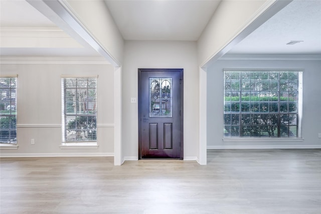 entrance foyer featuring baseboards, light wood-style flooring, visible vents, and crown molding