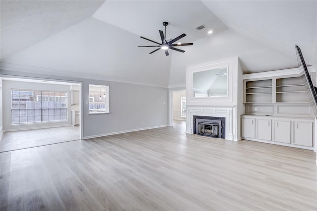 unfurnished living room with light wood finished floors, plenty of natural light, ceiling fan, and a high end fireplace